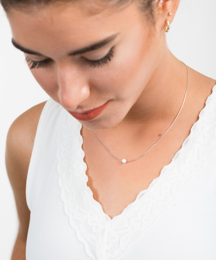 A woman wear a Sterling silver snake chain necklace with 5mm  synthetic Opal in White color