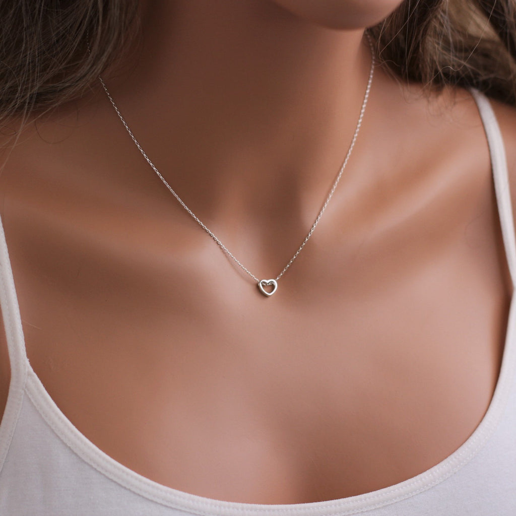 A woman is wearing a tiny necklace with a brilliant heart pendant-AlinMay