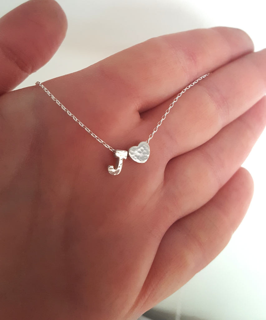 The model shows on her hand the letter J and tiny Heart charm in finish hammered on a delicate sterling silver Cable chain 