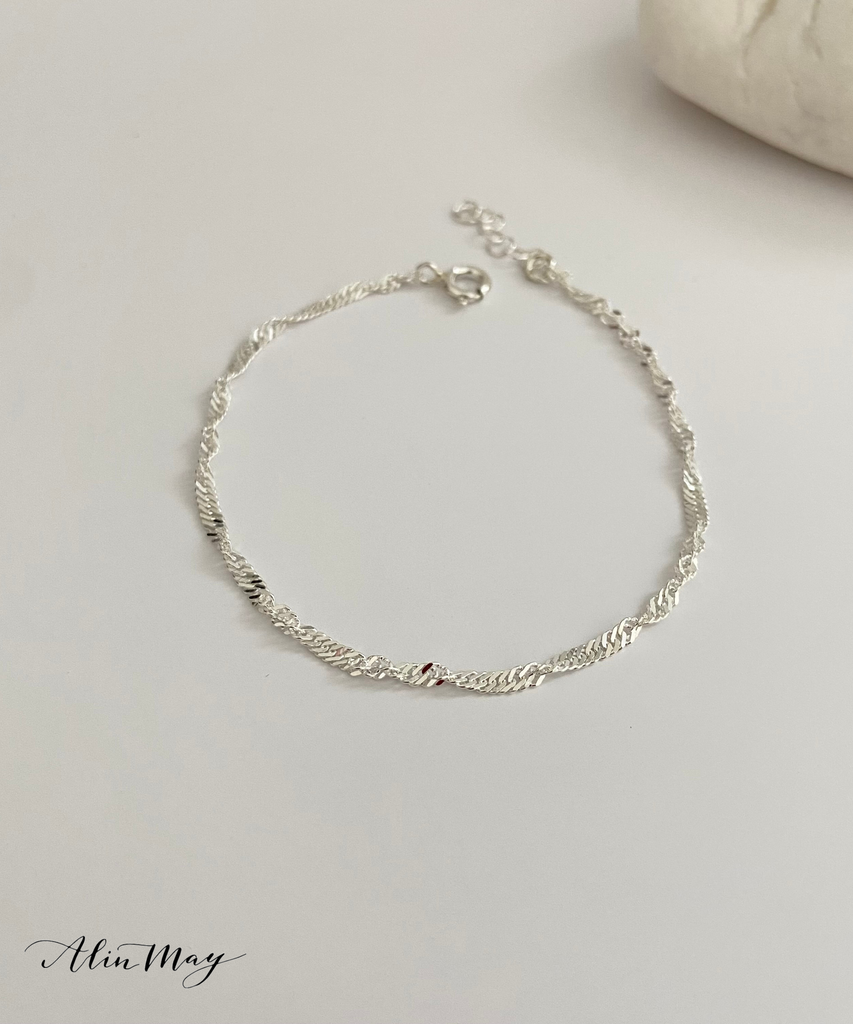 The picture shows a captivating dainty Singapore chain necklace on a white surface