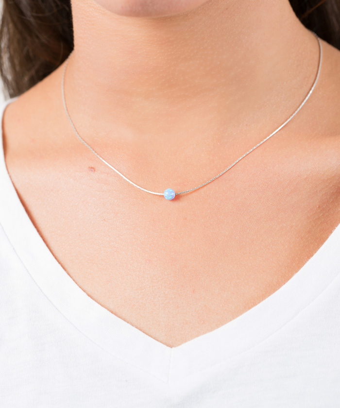 A woman wear a Sterling silver snake chain necklace with 5mm  synthetic Opal in light Blue color