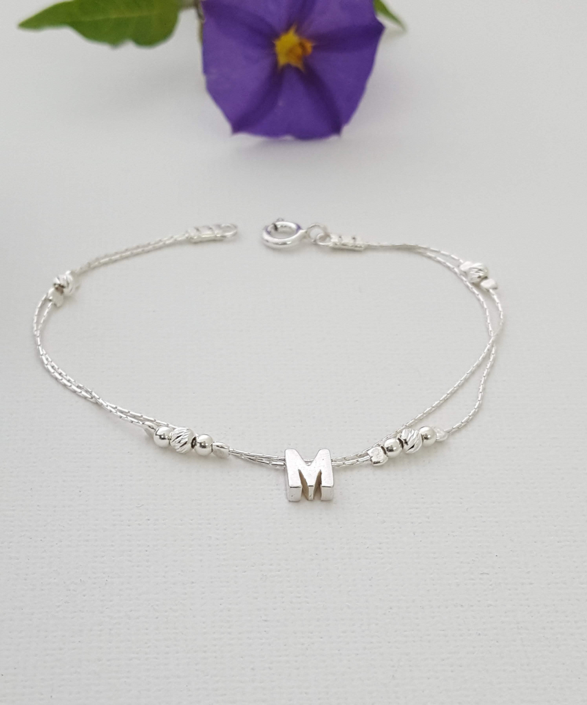 Stunning sterling silver initial bracelet with the letter 'M' that decorated with tiny silver beads on a white surface, adding a personalized and stylish touch to any outfit-AlinMay