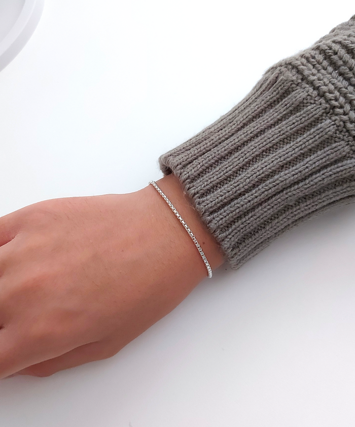 "Stylish model wearing round box chain bracelet in sterling silver on a clean white surface."