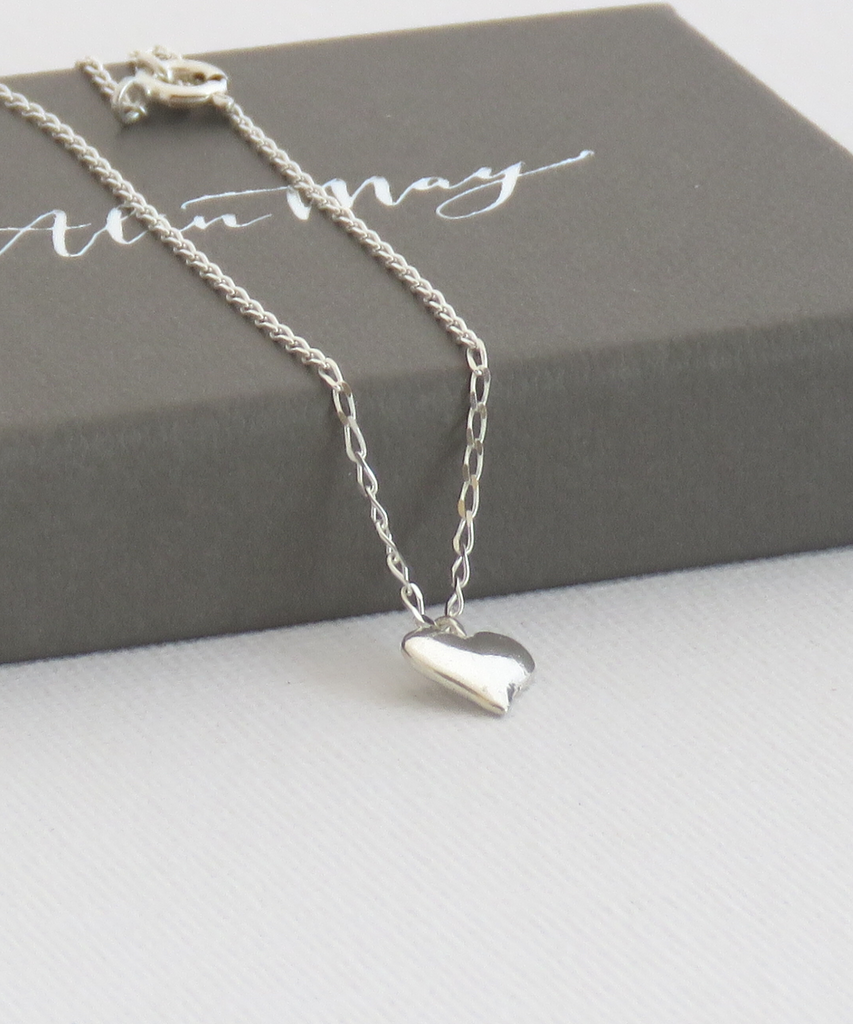 The picture shows a tiny puffy heart necklace on an AlinMay gift box