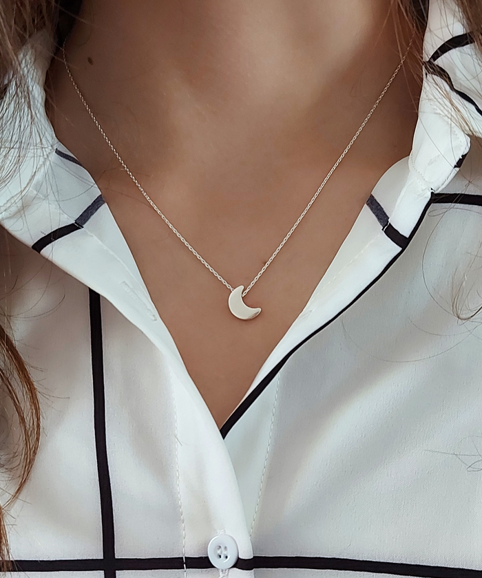 Image: A woman wearing a sterling silver moon necklace, showcasing its elegant and celestial design-AlinMay