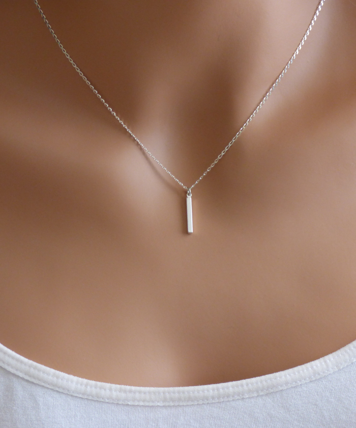 Model wearing small bar pendant necklace in sterling silver