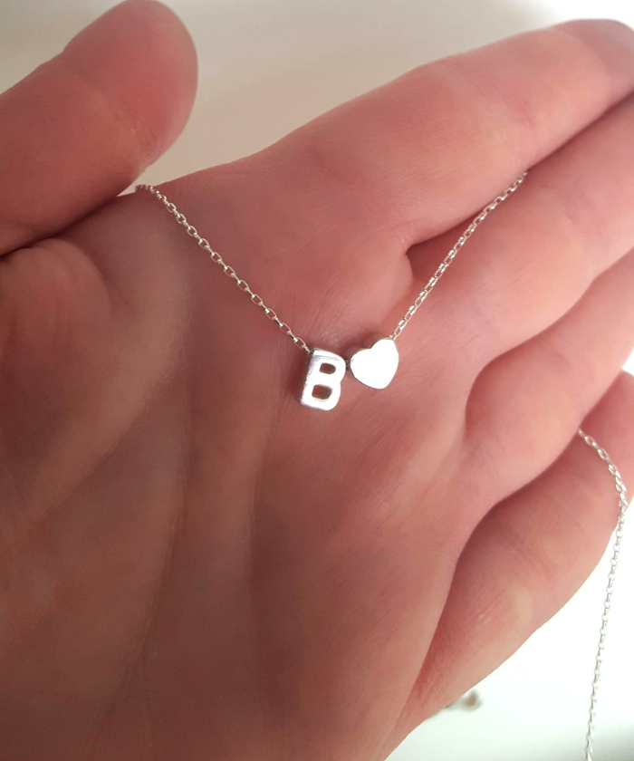 The model shows on her hand the letter B and tiny Heart charm in finish smooth on a delicate sterling silver Cable chain 