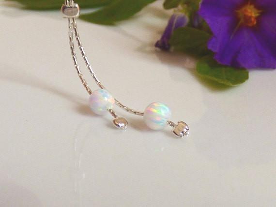 Two tiny White opal beads on a silver chain.