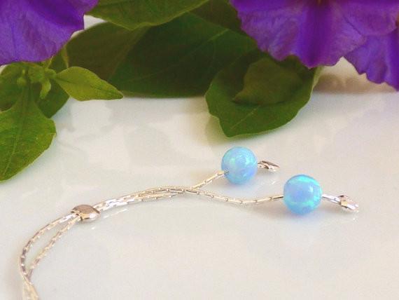 Two tiny blue opal beads suspended on Sterling silver delicate chain.