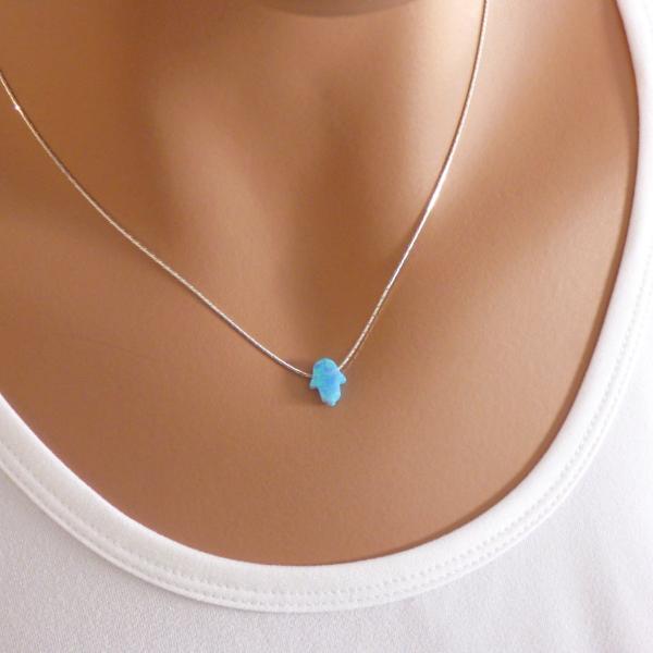 A woman is wearing a Silver necklace with a Blue Hamsa hand-AlinMay