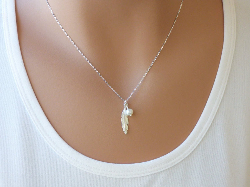 A woman is wearing a feather necklace with freshwater pearl in Sterling silver-AlinMay