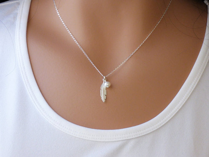 A woman is wearing a feather necklace with tiny pearl in Silver-AlinMay