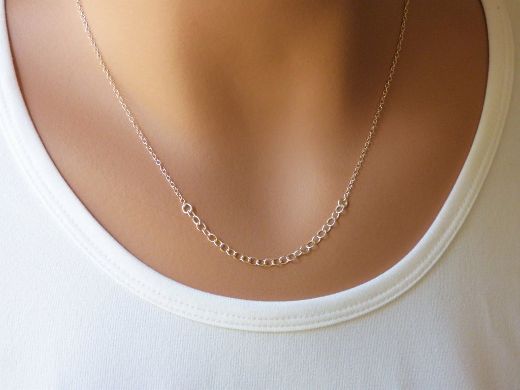 A woman is wearing a minimalist  sterling silver necklace with a tiny circles-AlinMay