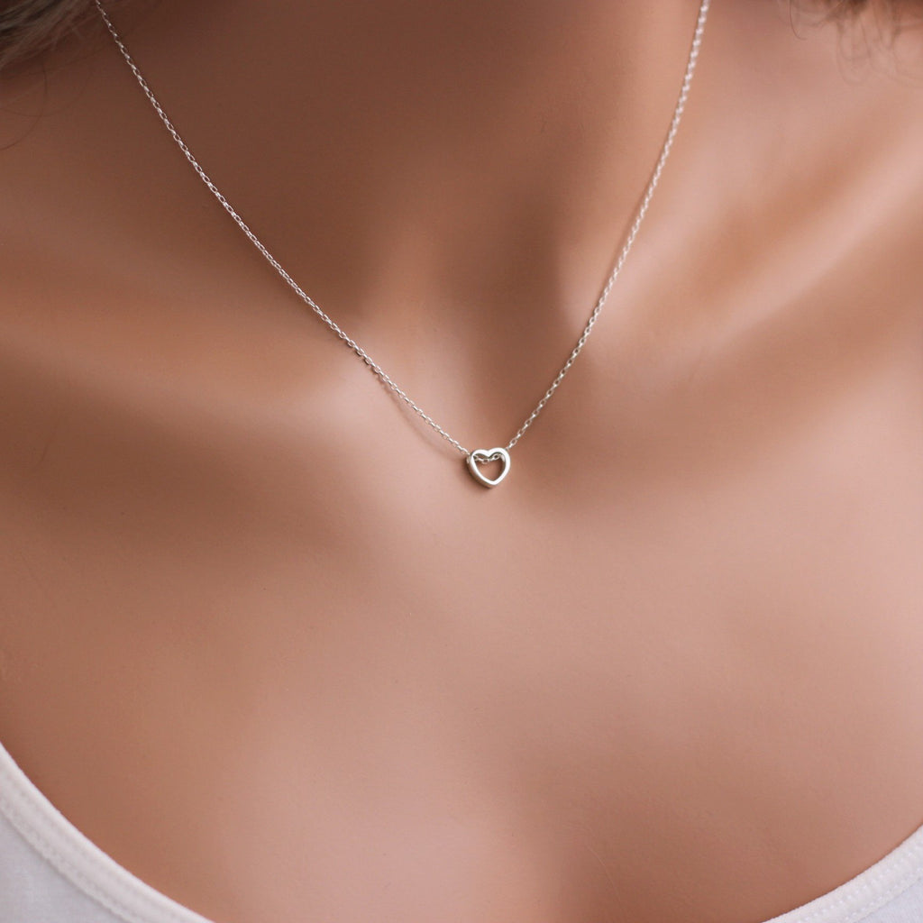 A woman is wearing a silver necklace with a tiny heart-AlinMay